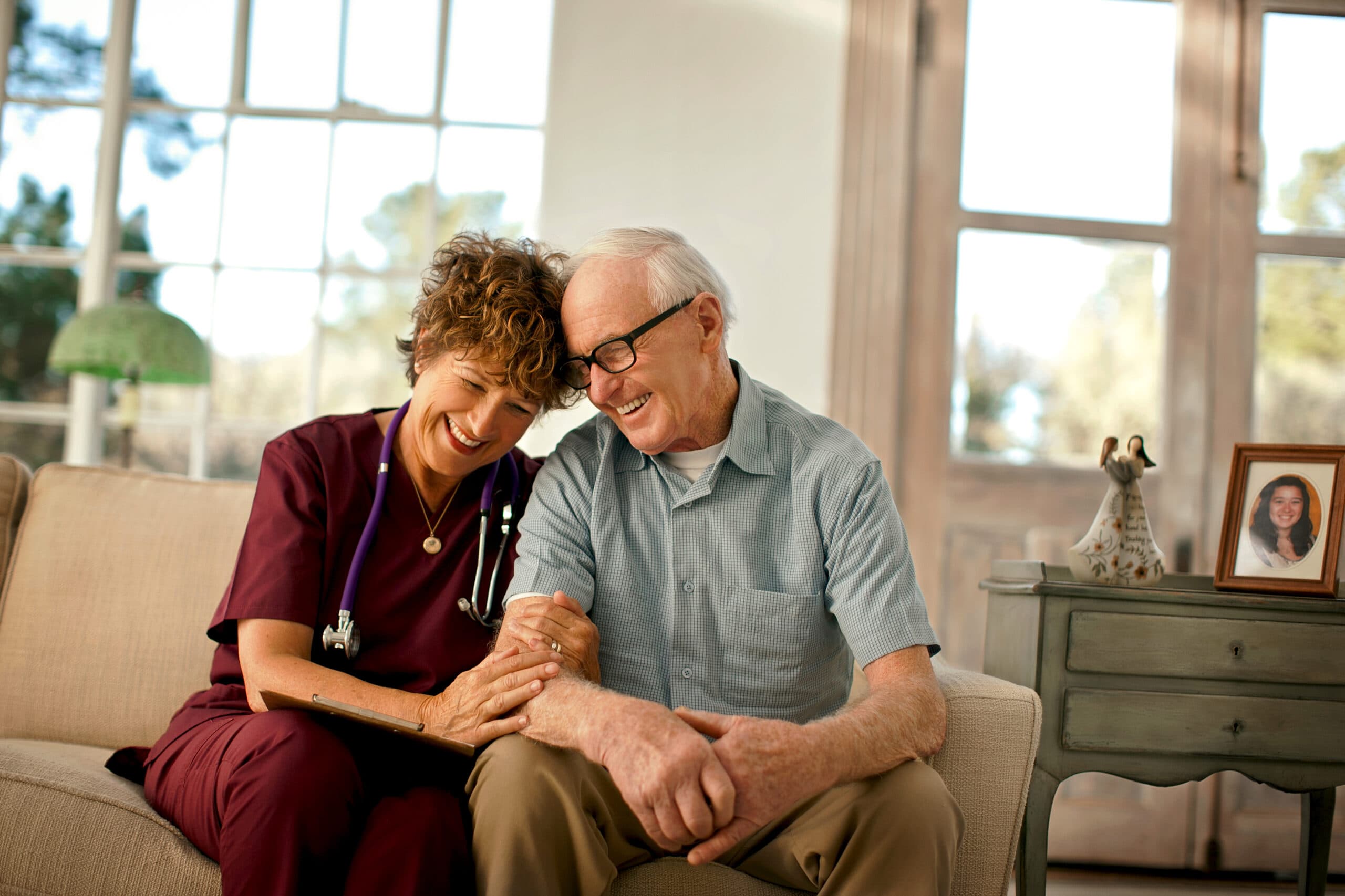 Smiling nurse comforting an elderly patient.